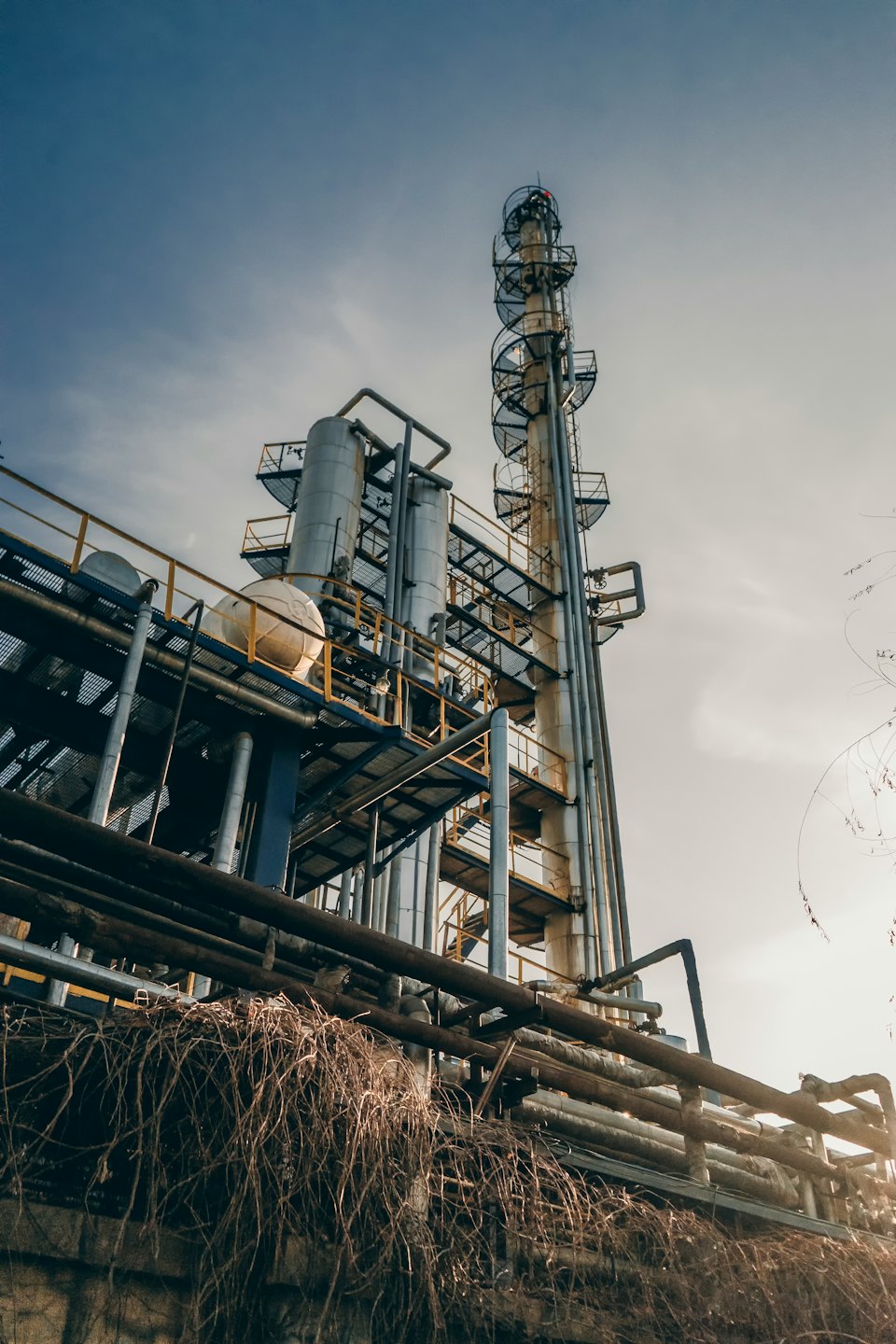 Impianto chimico industriale con colonne di distillazione e serbatoi di stoccaggio.